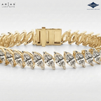 A gold tennis bracelet with marquise-cut clear stones, shown on a clean white background with ARIAS Lara Gutta branding and a Sparkle certification logo.