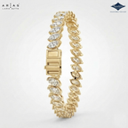 A gold tennis bracelet with marquise-cut clear stones, shown on a light gray background. The brand logos 'Arias Lara Gutta' and 'Sparkle' are visible in the corners.