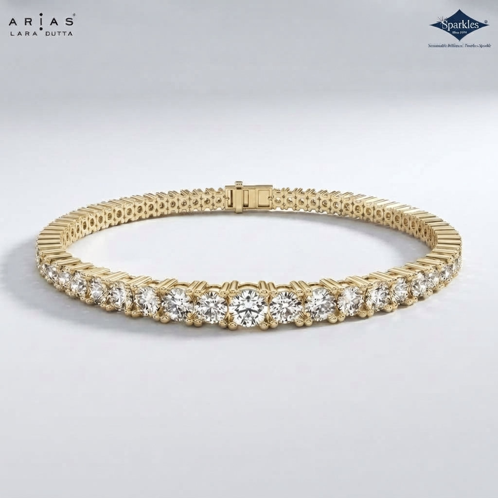A gold tennis bracelet with a row of round-cut clear stones, displayed on a light gray background. The brand logos 'ARIA'S LARA GUTTA' and 'Sparkle' are visible in the top corners.