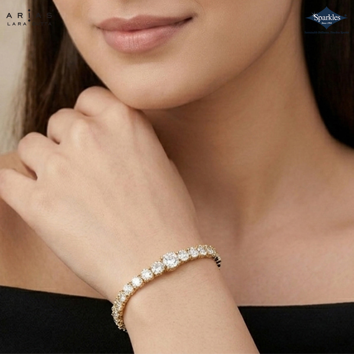 A close-up lifestyle shot of a model wearing a gold tennis bracelet adorned with sparkling clear stones. The brand logos for 'Ariane Lara' and 'Sparkles' are visible in the corners.
