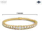 A yellow gold tennis bracelet with a row of clear round-cut stones, shown on a white background with a measurement line indicating a 7-inch width. The ARIAS Lara Dutta brand logo is in the top left, and the Sparkle Southend on Sea display logo is in the top right.