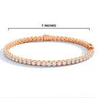A rose gold tennis bracelet with clear gemstones, shown on a white background with a black measurement line indicating a width of 7 inches.