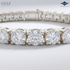A close-up studio shot of a silver tennis bracelet featuring round brilliant-cut diamonds. The brand logos for 'Ariás Lara Dutta' and 'Sparkles' are visible in the top corners.