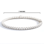 A silver tennis bracelet with clear stones, shown on a white background with a black measurement line above it labeled '7 INCHES'.
