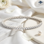 Silver bracelet with diamonds on a white surface with flowers and pearls