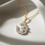 A gold chain necklace with an Om symbol pendant, featuring silver pavé-set clear stones, displayed on a soft white fabric background with dramatic shadows.