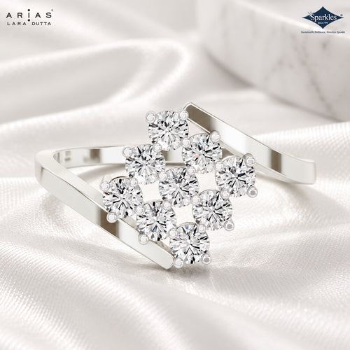 A silver-toned open cuff ring with a cluster of round clear gemstones, photographed on white satin fabric. Brand marks 'Ariás Lara Dutta' and 'Sparkle Sustainable Gold, Silver & Gemstone Specialist' are visible in the corners.