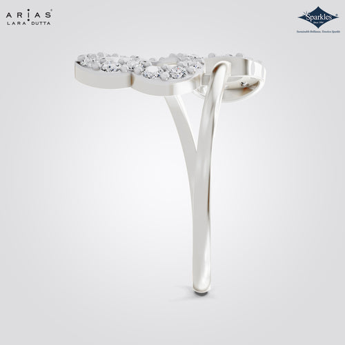 A silver-toned Arias Lara Dutta ring featuring a heart-shaped pavé diamond top with two curved bands, shown on a light gray gradient background with brand logos.