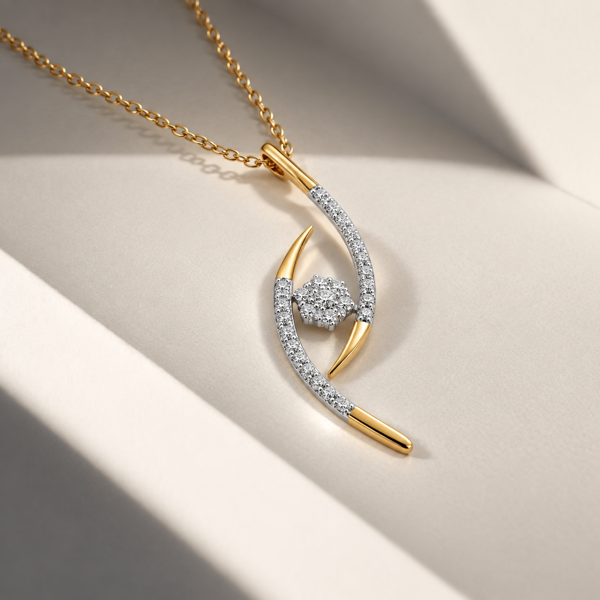 Yellow gold diamond swirl pendant necklace lying flat on a smooth neutral background