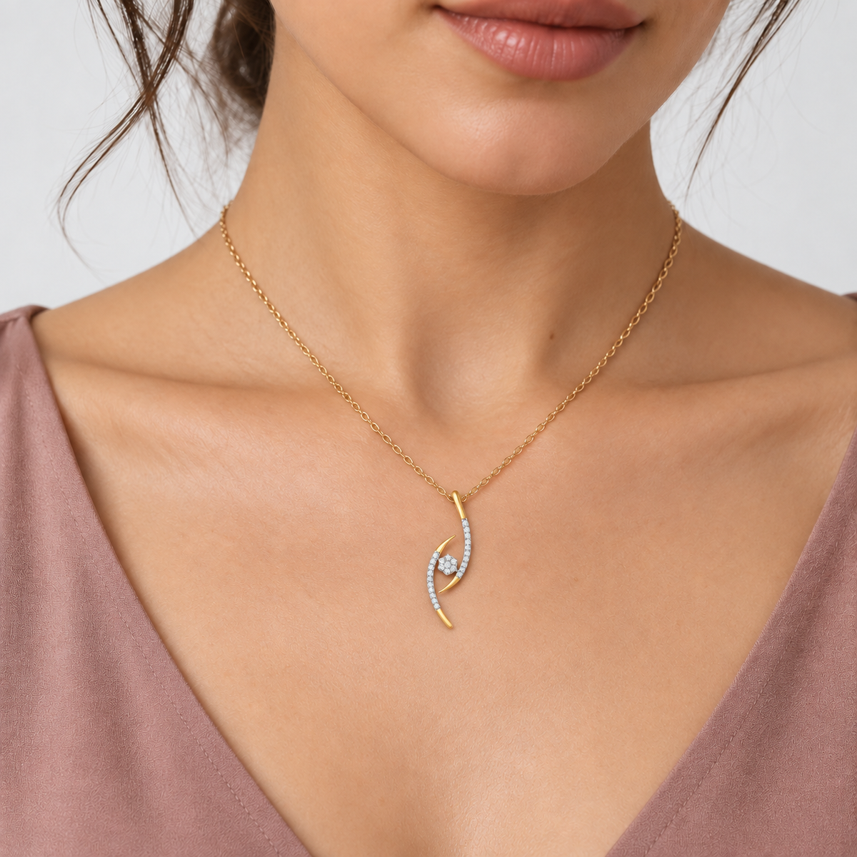 A close-up of a model wearing a delicate gold chain necklace with a curved, wave-like pendant adorned with small clear stones and a central white gemstone, paired with a mauve top.