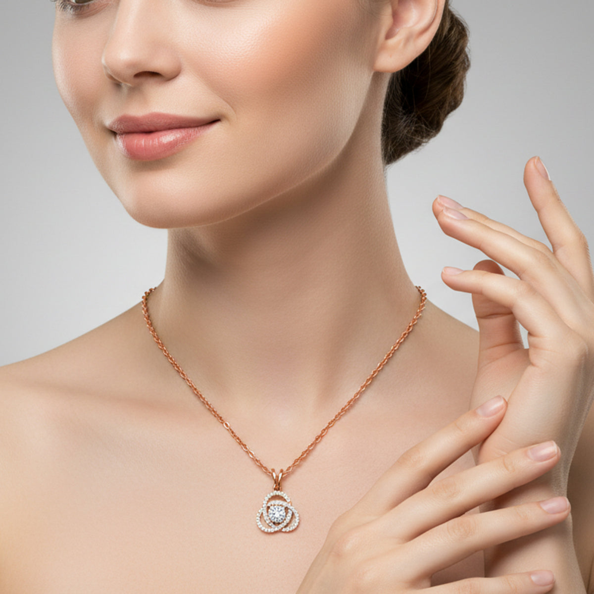 Woman wearing a rose gold necklace with a diamond pendant against a neutral background