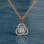 Rose gold necklace with a diamond pendant on a blue background