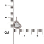 Heart-shaped pendant with textured surface on a ruler for scale