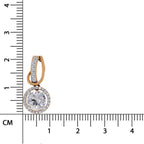A single round-cut diamond pendant in a rose gold setting with a halo of small clear stones, shown next to a centimeter ruler for scale on a white background.
