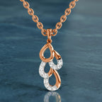 Rose gold and silver pendant necklace on a blue textured background