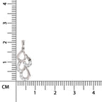 Silver pendant with clear stones next to a ruler for scale on a white background