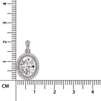 An oval diamond pendant in a silver-toned setting, shown next to a centimeter ruler to indicate its size.