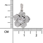 A silver-toned flower-shaped pendant with a central round clear gemstone and surrounding small clear stones, shown next to a centimeter ruler for scale on a white background.