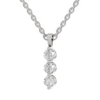 A silver-toned necklace featuring a vertical drop pendant with three round clear gemstones in a prong setting, suspended from a matching chain against a plain white background.