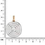 A square pendant with concentric rings of clear stones and a central princess-cut stone, shown next to a centimeter ruler for scale. The pendant features a gold bail and gold accents.