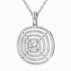 A silver-toned round pendant necklace featuring a central princess-cut clear gemstone surrounded by concentric rings of small pavé-set clear stones, suspended from a matching chain on a light gray background.
