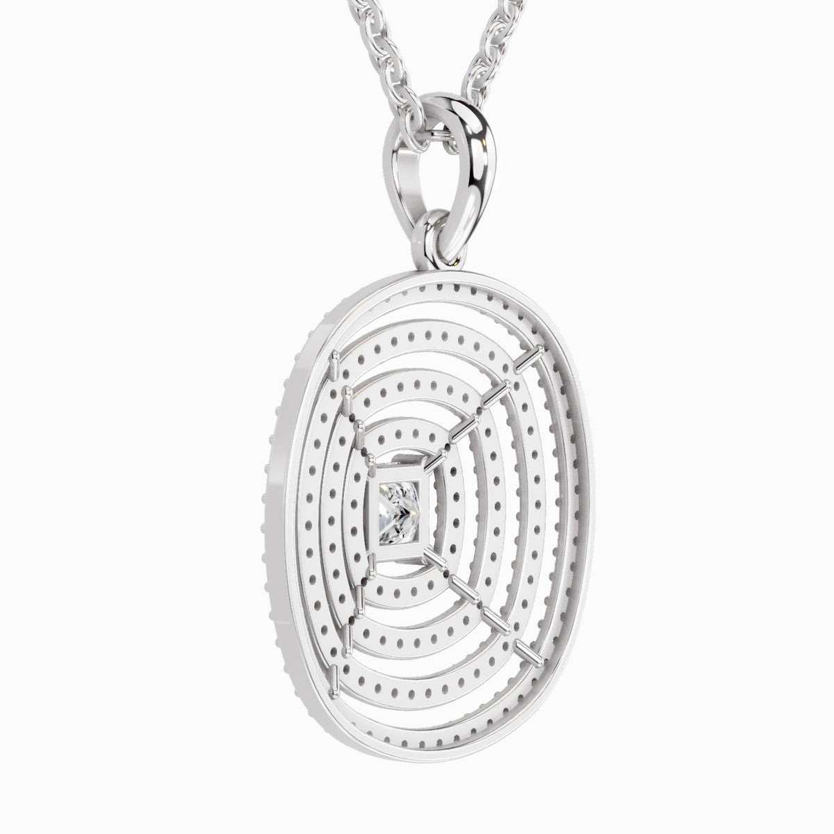 A silver oval pendant necklace featuring concentric circular patterns, a textured outer edge, and a small central clear gemstone, suspended from a silver chain against a light gray background.