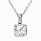 A silver square pendant necklace featuring a round-cut clear center stone surrounded by a halo of small clear stones, suspended from a silver chain on a light gray background.