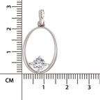 A silver oval pendant with a single clear round-cut gemstone, shown next to a centimeter ruler for scale on a white background.