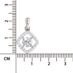 A silver diamond-shaped pendant with a central round clear gemstone and a halo of small clear stones, shown next to a centimeter ruler for scale on a white background.