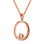 Rose gold necklace with a circular open pendant adorned with small clear stones and a rotating stone, shown on a white background.