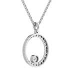 A silver-toned necklace featuring a circular open pendant with a small rotating bead inside, set against a plain white background.
