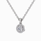 A silver chain necklace with a round pendant featuring a halo of small clear stones around a central round stone, shown on a plain white background.