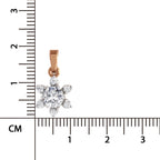 A small flower-shaped pendant in rose gold with clear gemstones, shown next to a centimeter ruler for scale on a white background.