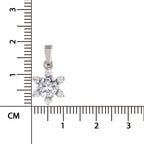 A silver flower-shaped pendant with clear gemstones, shown next to a black ruler in centimeters to indicate its small size.