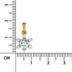 A small gold flower-shaped pendant with clear gemstones, shown next to a centimeter ruler for scale on a white background.