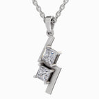 A silver pendant necklace featuring two princess-cut clear gemstones set in a geometric, stepped silver frame, suspended from a silver chain against a plain white background.
