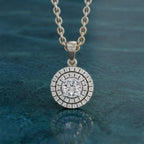 Silver necklace with a round diamond pendant on a blue textured background