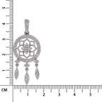 A silver-toned dreamcatcher-style pendant with clear pavé stones, shown next to a black ruler with centimeter markings to indicate scale.