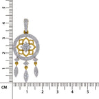 A gold and diamond pendant with a circular frame, floral motif, and three dangling teardrop charms, shown next to a centimeter ruler for scale on a white background.