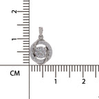 A silver pendant with a round-cut clear center stone and a halo of small clear stones, shown next to a centimeter ruler for scale on a white background.