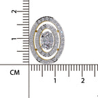 An oval cluster pendant or brooch with a central round clear gemstone surrounded by double rows of small clear stones in a silver-toned setting with gold-toned accents, shown next to a centimeter ruler for scale on a white background.