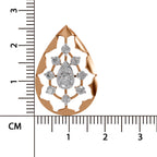 A teardrop-shaped rose gold pendant with a floral cutout design and a central pear-cut diamond surrounded by smaller round diamonds, shown with a centimeter ruler on a white background.