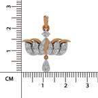 A two-tone diamond pendant with rose gold and white gold elements, shown next to a black ruler with centimeter markings to indicate its size.