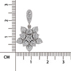 A silver-toned flower-shaped pendant with clear gemstones, shown next to a black ruler with centimeter markings to indicate scale on a white background.
