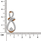 A gold and white stone infinity-shaped pendant with a central round diamond, shown next to a centimeter ruler for scale on a white background.