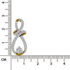 A gold and white stone infinity-shaped pendant with a central round diamond, shown next to a centimeter ruler for scale on a white background.