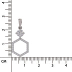 A silver-toned hexagonal pendant with a round clear gemstone at the top, shown next to a centimeter ruler for scale on a white background.