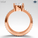 A rose gold ring by Lara Dutta Aria's, featuring a round-cut diamond center stone and pavé-set diamonds along the band, shown from a top-down view on a light gray background.