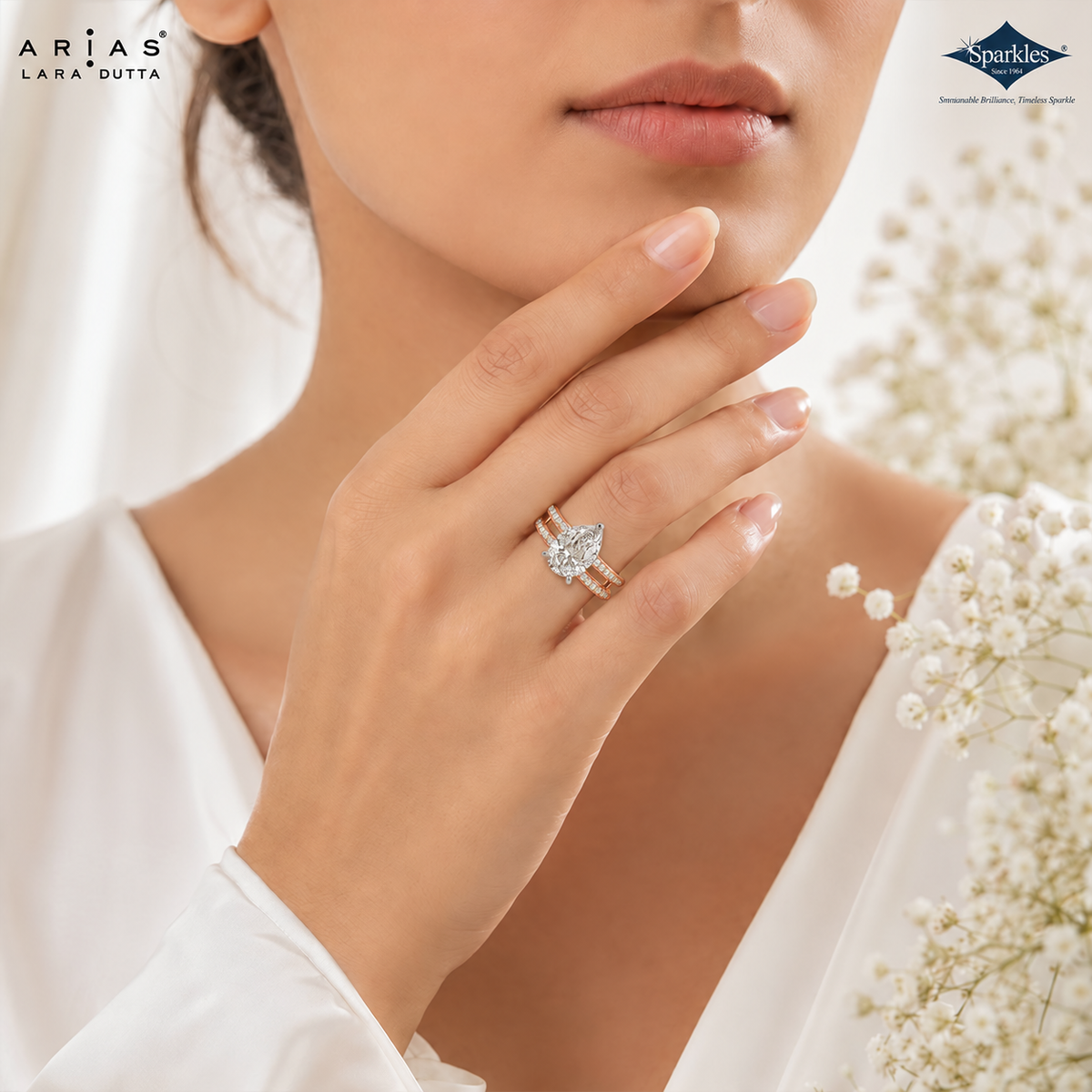 A close-up lifestyle shot of a model wearing a Lara Dutta Arias Sparkle ring. The ring features a pear-cut diamond set on a yellow gold band with a silver-toned pavé accent.