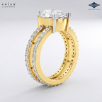 A yellow gold ring shown from the back, featuring a large round-cut diamond solitaire at the top and pavé-set diamonds along the split shank. The brand logos 'Ariás Lara Dutta' and 'Sparkle' are visible in the corners.